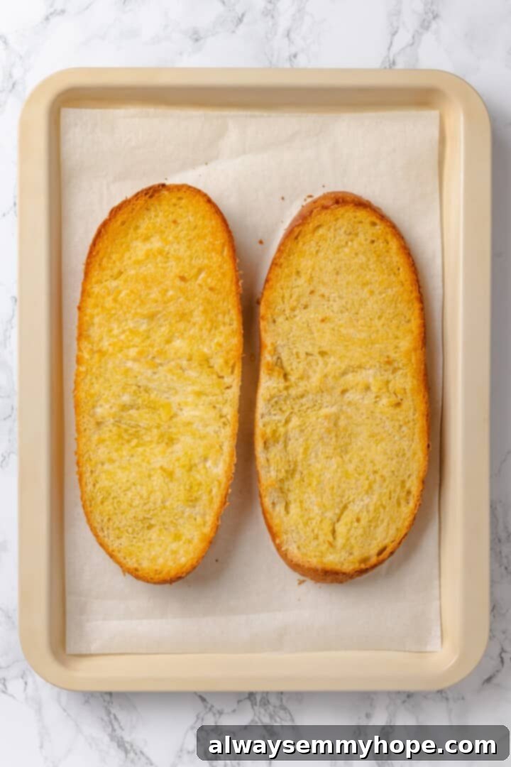 This vegan French Bread Pizza recipe is cheesy, easy and that thick, toasty base puts regular crust to shame. I’ve got two topping options! Overhead view of two toasted French bread loaf halves for vegan pizza