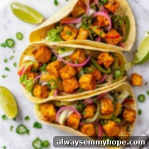Overhead view of 3 crispy tofu tacos on marble tray