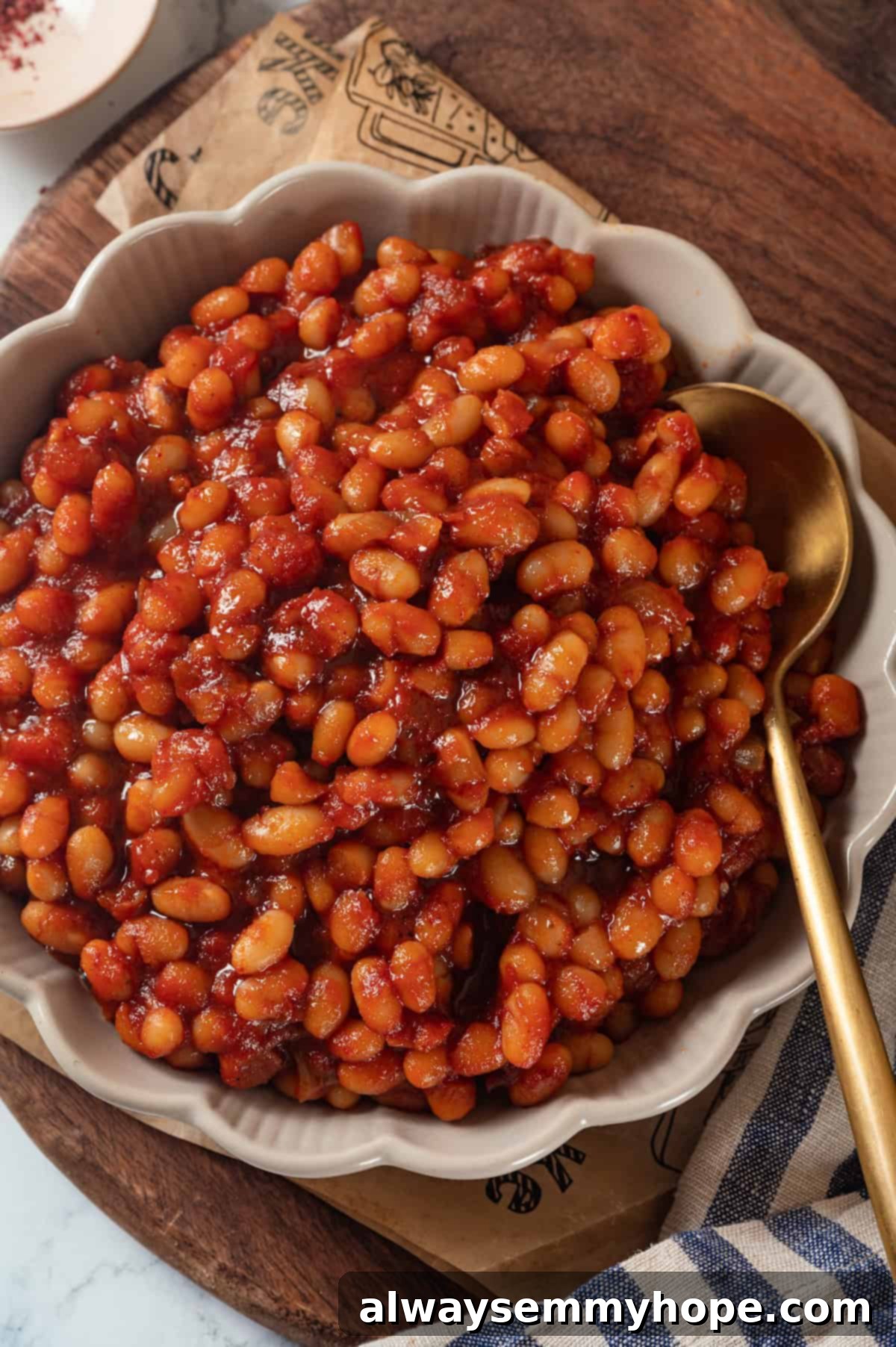 This vegan Baked Beans recipe has all the sweet, tangy, smoky flavour you love! Starting with canned beans makes this recipe a cinch. Overhead view of vegan baked beans with spoon