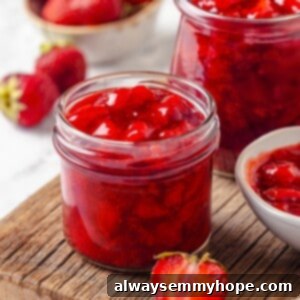 Jars of homemade strawberry filling, showcasing a vibrant red color and thick texture