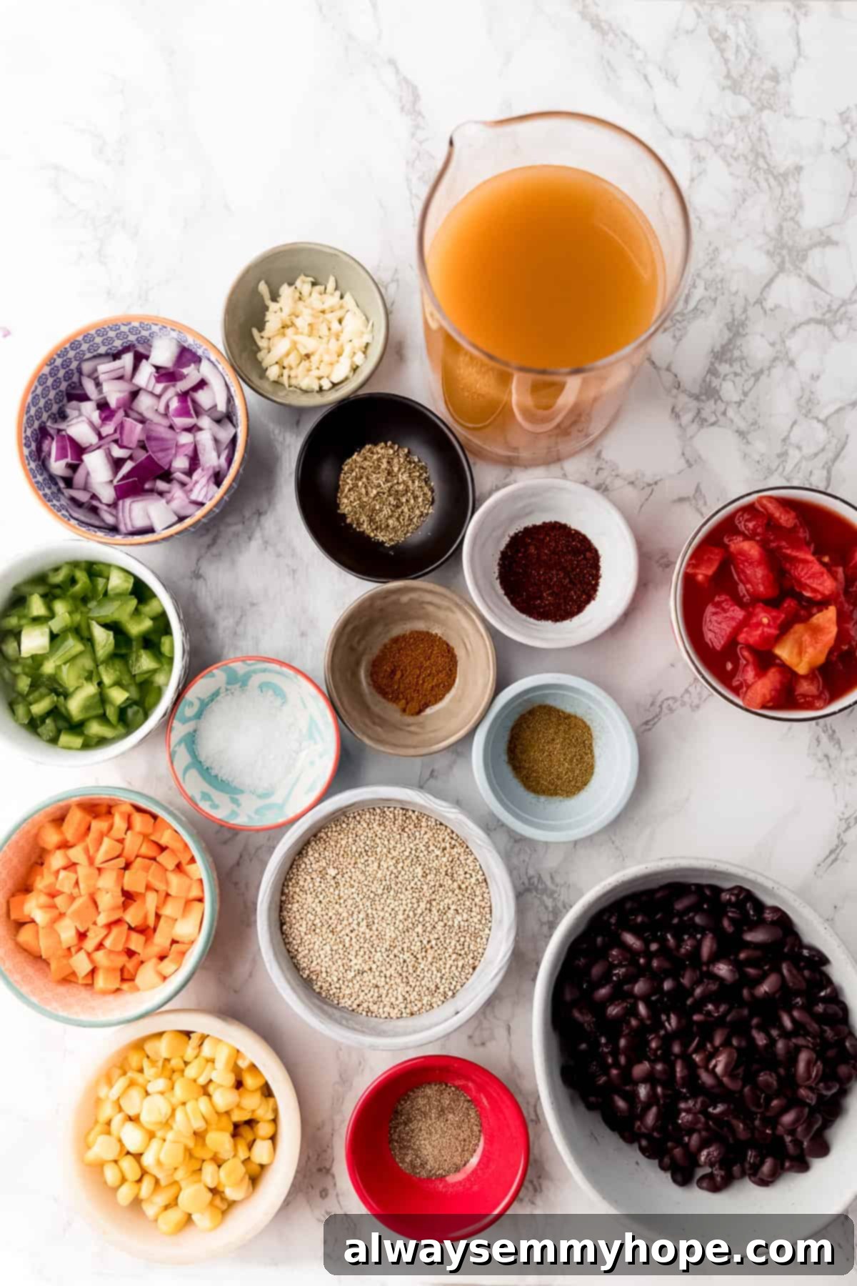 ingredients for vegan chili laid out on a table, including beans, tomatoes, quinoa, and spices