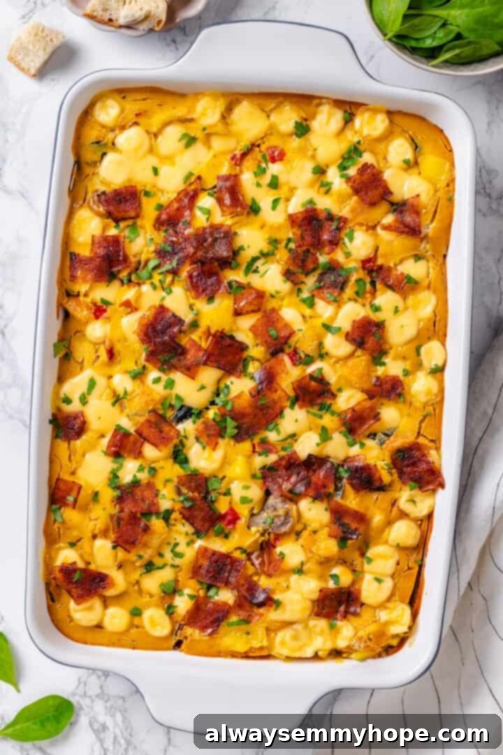 An overhead shot of the vegan overnight breakfast strata in a baking dish, garnished with crumbled vegan bacon, ready for serving.