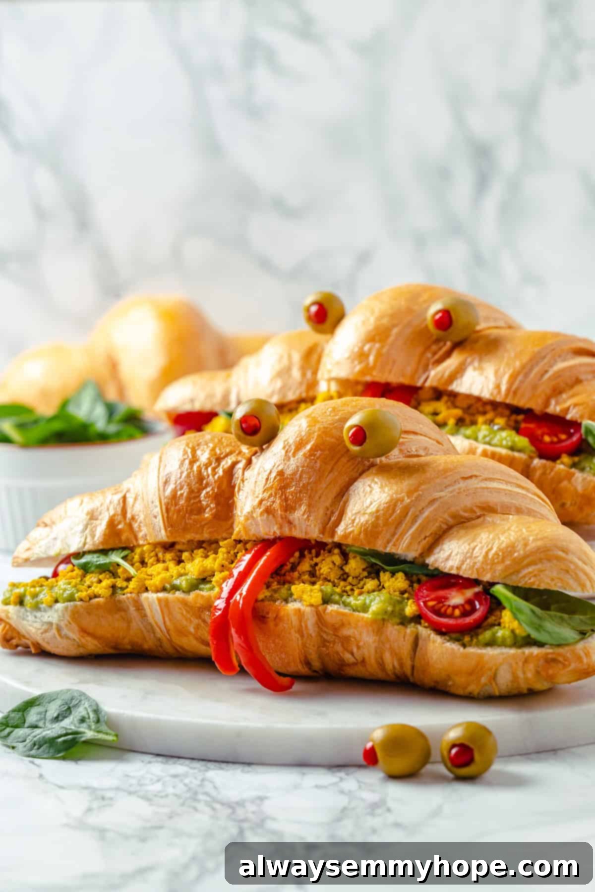 Two monster breakfast sandwiches on marble board for Halloween