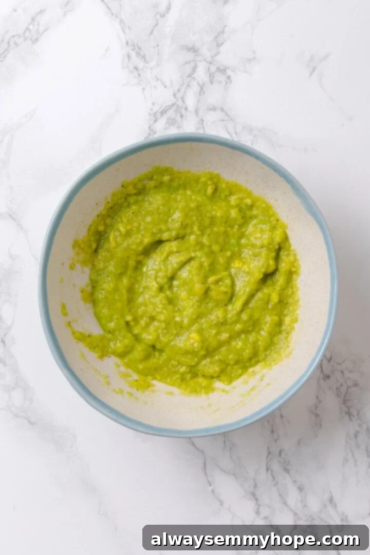 Prepare the vibrant green avocado slime, a key component for your Monster Breakfast Sandwich. Overhead view of vibrant green avocado slime in a bowl