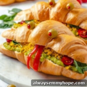 Two vegan monster breakfast sandwiches on marble board for a Halloween breakfast