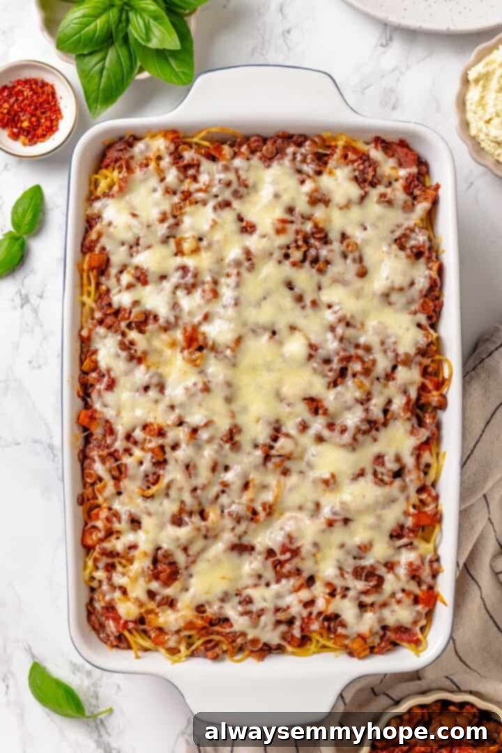 Overhead view of the vegan Million Dollar Spaghetti casserole baking in the oven, with the vegan mozzarella melting and bubbling to golden perfection.