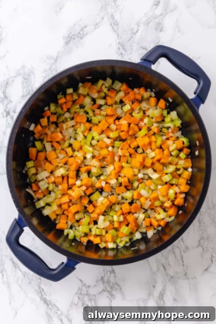 Diced carrots, celery, and onion gently sautéing in a large pot with olive oil.