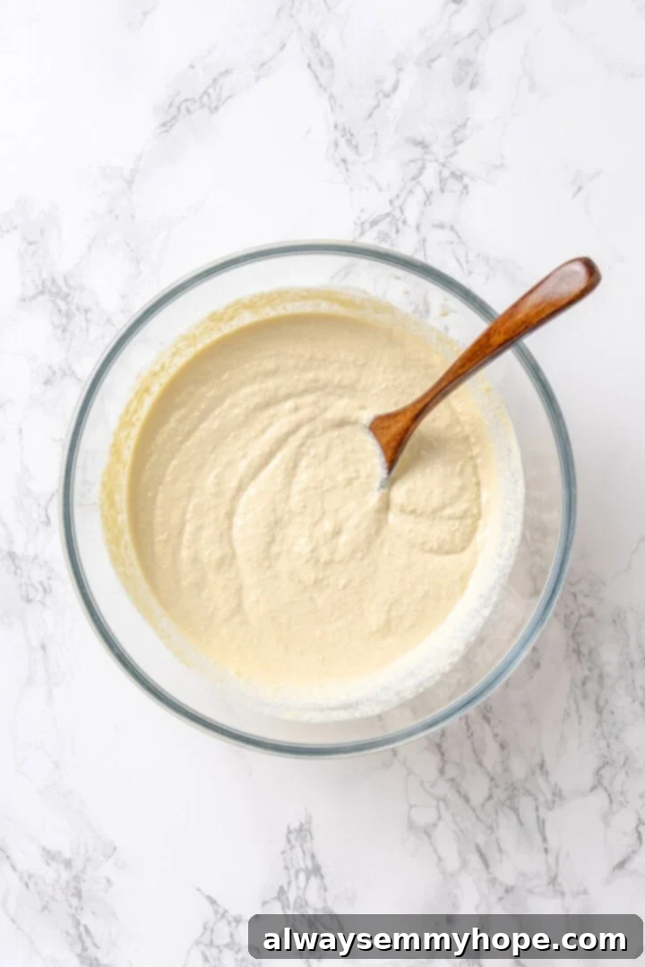 A bowl of creamy vegan ricotta mixture with plant milk, garlic powder, and nutritional yeast, ready to be layered.