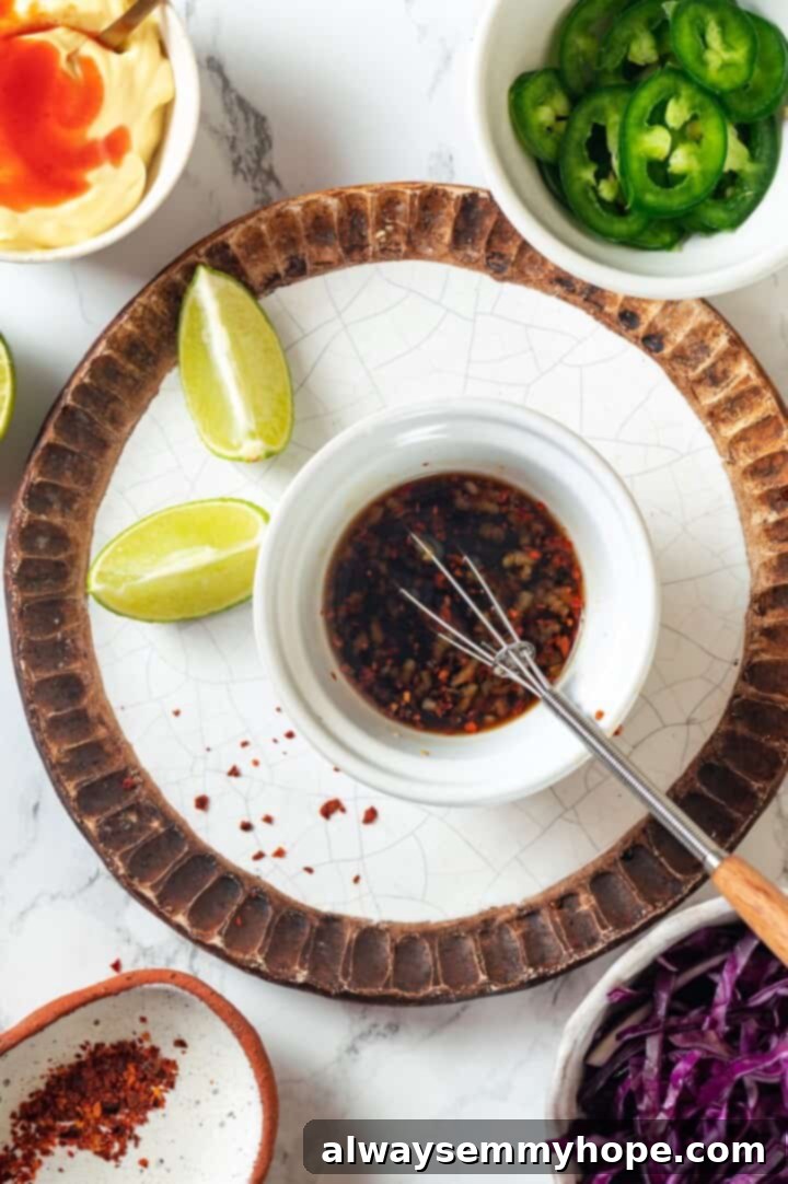 A small bowl containing the mixed nuoc cham sauce with a tiny whisk, ready for drizzling.