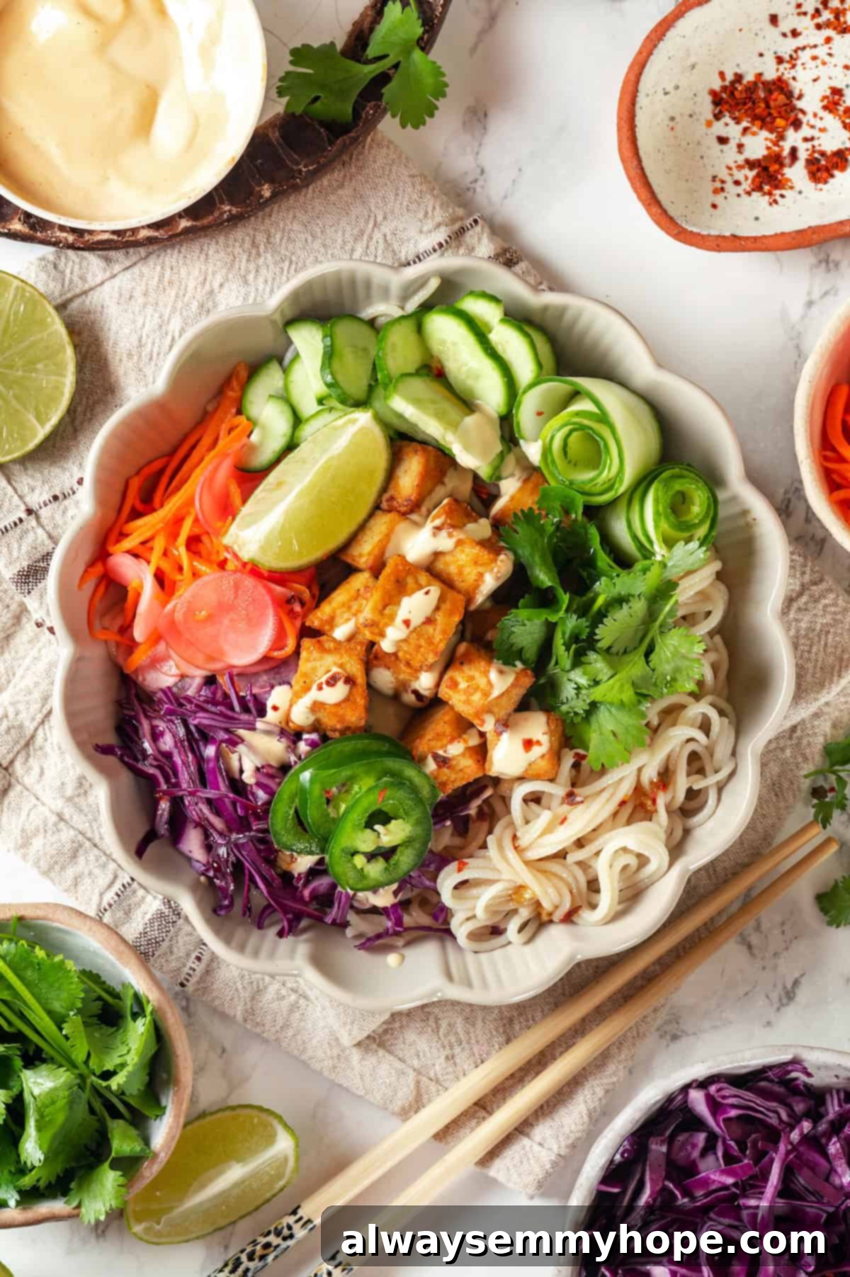 An inviting overhead shot of a fully assembled vegan banh mi bowl, showcasing the noodles, tofu, and colorful vegetables.