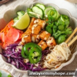 Vegan banh mi bowl with chopsticks tangled in noodles.