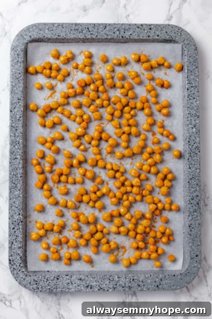 This vegan Caesar Pasta Salad is savoury, tangy and garlicky, with crunchy baked chickpeas, crisp romaine and tender pasta. Delicious! Seasoned chickpeas on sheet pan.