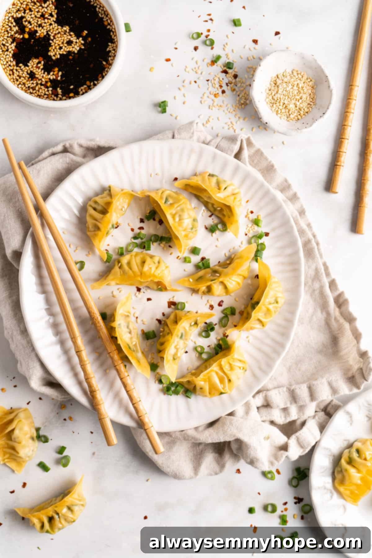Step-by-step instructions on how to make vegan potstickers at home! These Chinese dumplings are filled with tofu and veggies. So good! Overhead view of a perfectly plated dish of vegan potstickers, with their distinct golden-brown bottoms and tender steamed tops, accompanied by chopsticks for easy enjoyment.
