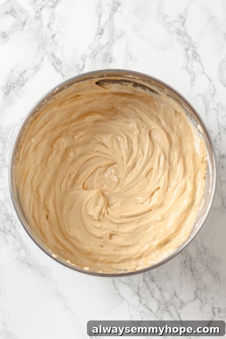The fully mixed Biscoff cheesecake filling in a large bowl, smooth and ready for baking.