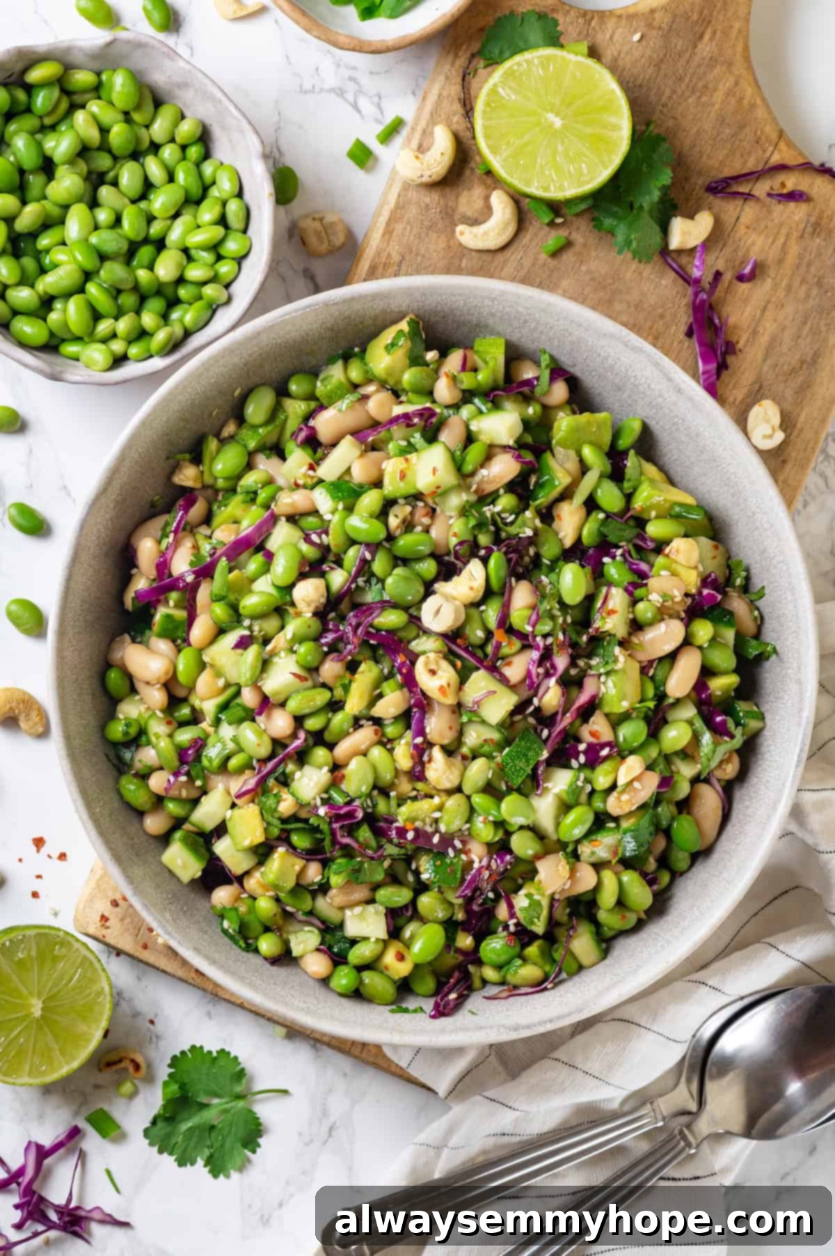 Edamame salad in a rustic bowl, garnished with fresh herbs and sesame seeds, set on a wooden cutting board.