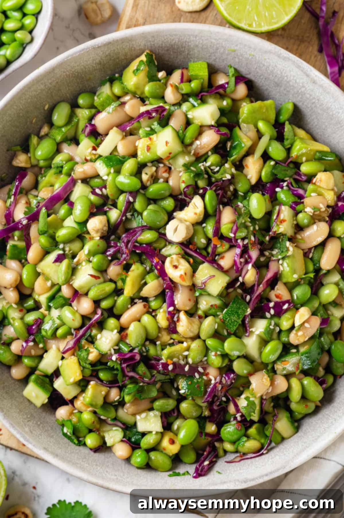 Bowl of edamame salad featuring a vibrant mix of green edamame, red cabbage, and cashews, ready to be served.