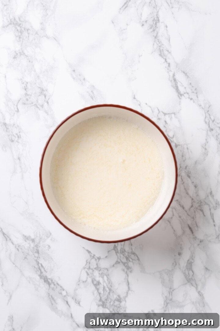Vegan buttermilk in bowl, a mixture of soy milk and apple cider vinegar, ready for use in the cake batter.