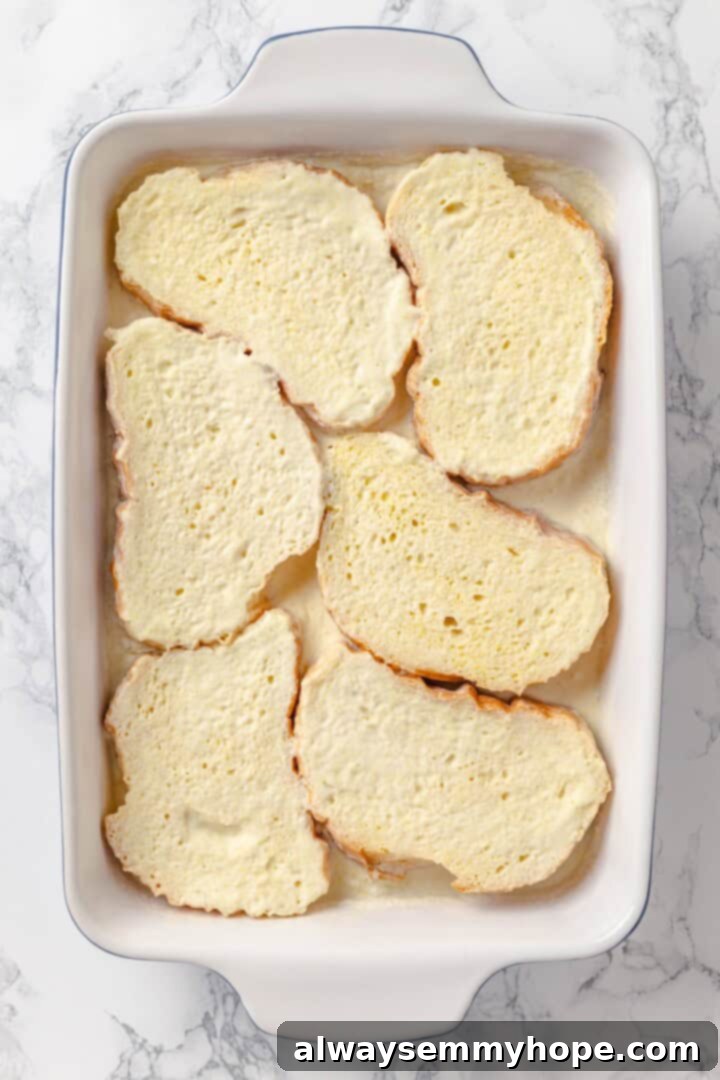 With a rich vegan custard and caramel, this Creme Brûlée French Toast has the flavour of the classic dessert in crowd-pleasing breakfast form! Bread soaking in custard in baking dish.