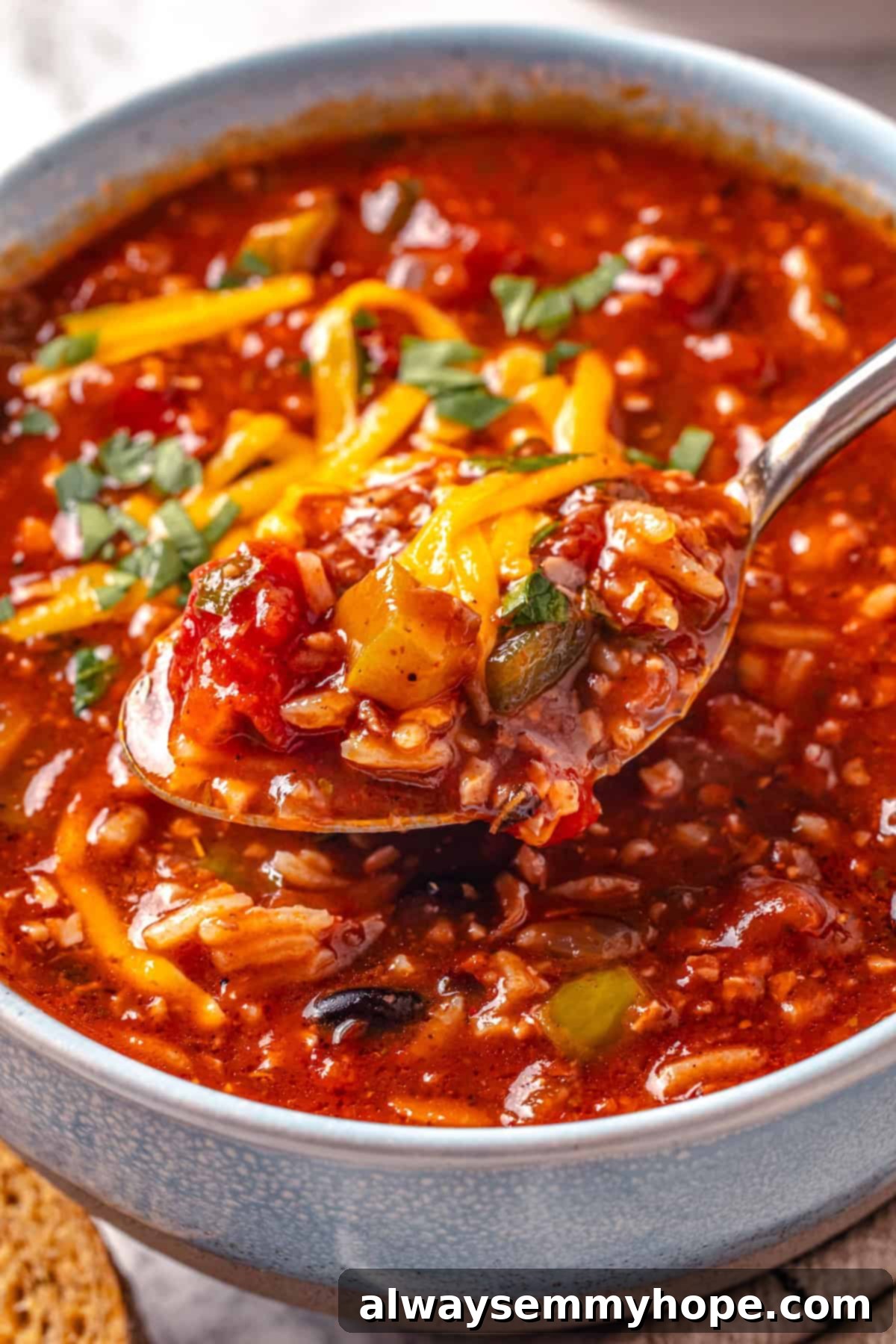 Spoonful of stuffed pepper soup in bowl.