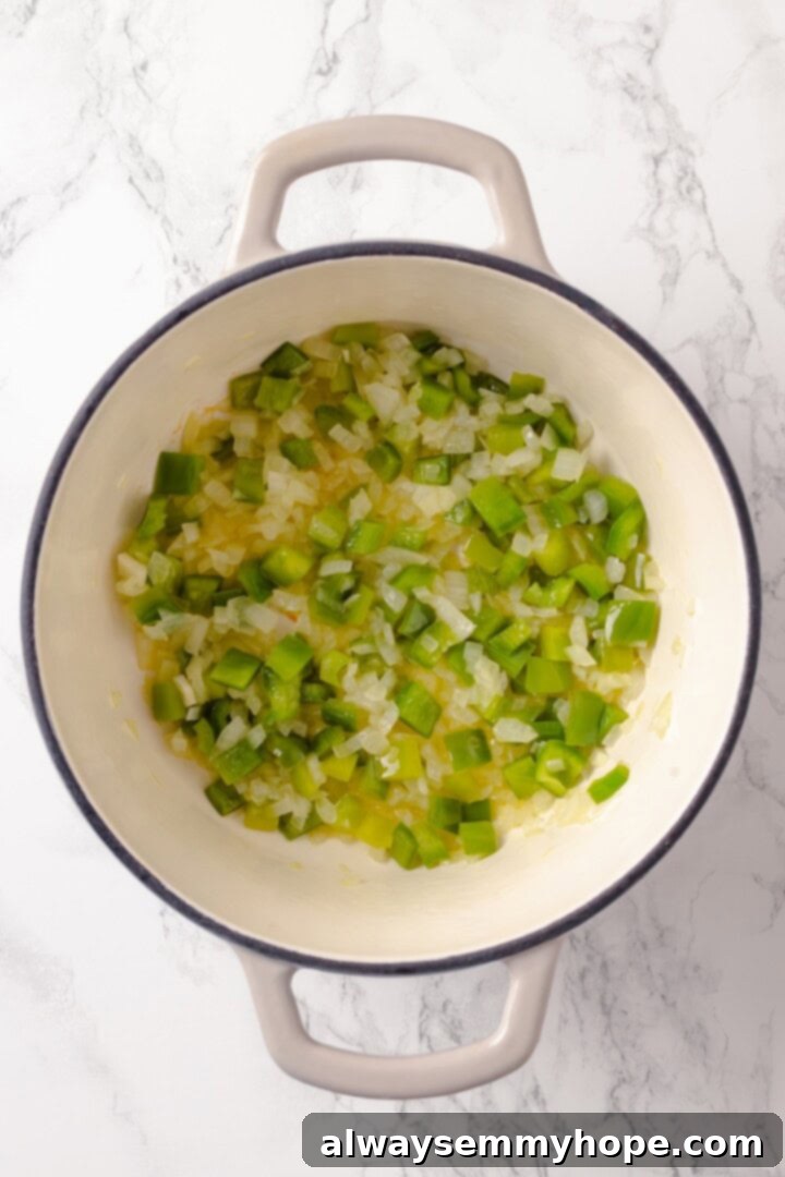 Onions and green peppers softening in Dutch oven.