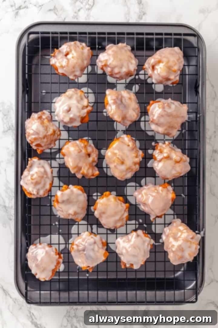 Tender apples, sticky glaze, and dough that’s crisp on the outside and pillowy soft inside make this the best vegan apple fritters recipe! Glazed vegan apple fritters resting on a wire rack over a sheet pan.