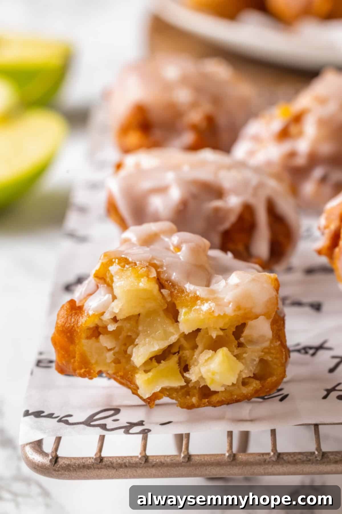 Tender apples, sticky glaze, and dough that’s crisp on the outside and pillowy soft inside make this the best vegan apple fritters recipe! A vegan apple fritter torn open to reveal tender apple pieces and fluffy dough inside.