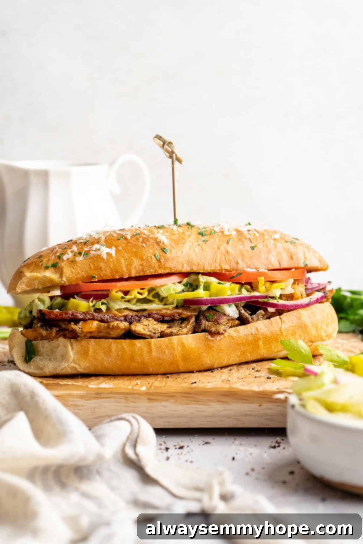 Vegan grinder sandwich on wooden cutting board.