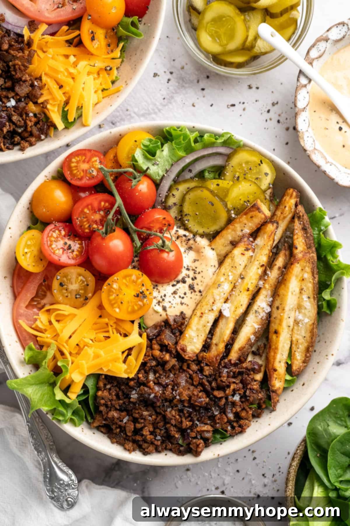 Vegan cheeseburger bowl with fries and burger sauce. A delicious and healthy plant-based meal. Vegan cheeseburger bowl with fries and burger sauce.