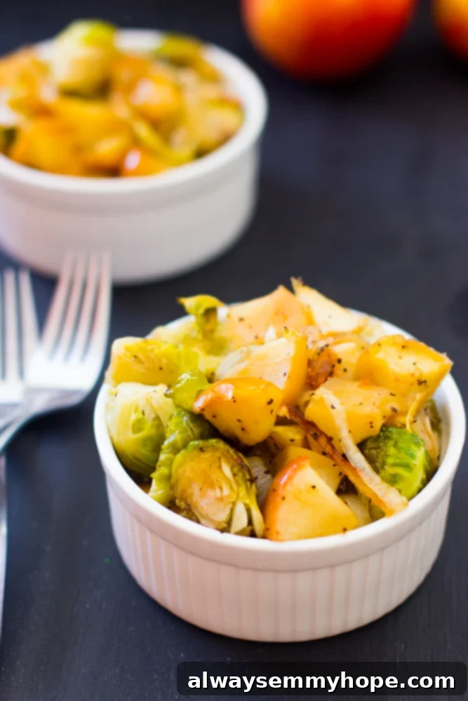 Two ramekins filled with perfectly roasted maple brussels sprouts, onions, and apples.