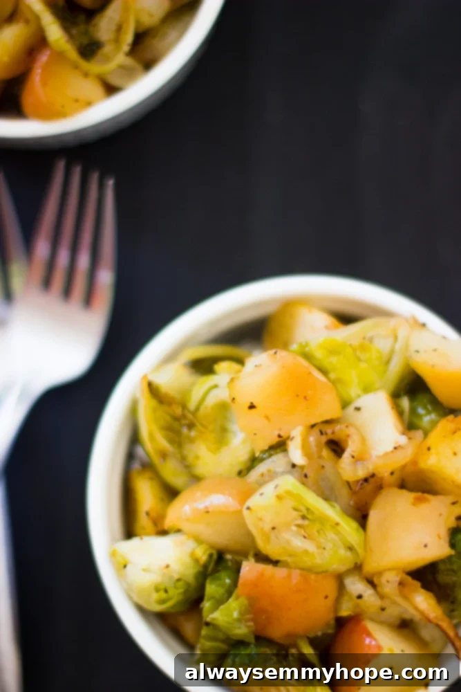Overhead shot of maple roasted brussels sprouts in a white ramekin with forks, showcasing the caramelized texture.