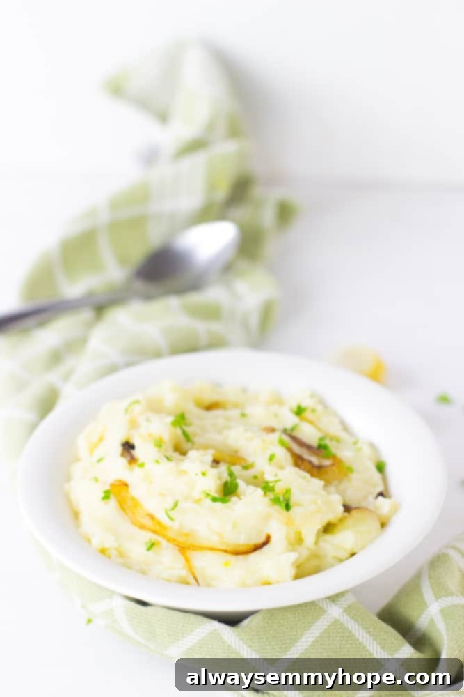A serving of rich, creamy vegan garlic mashed potatoes in a white bowl, garnished with fresh herbs, ready to be enjoyed.
