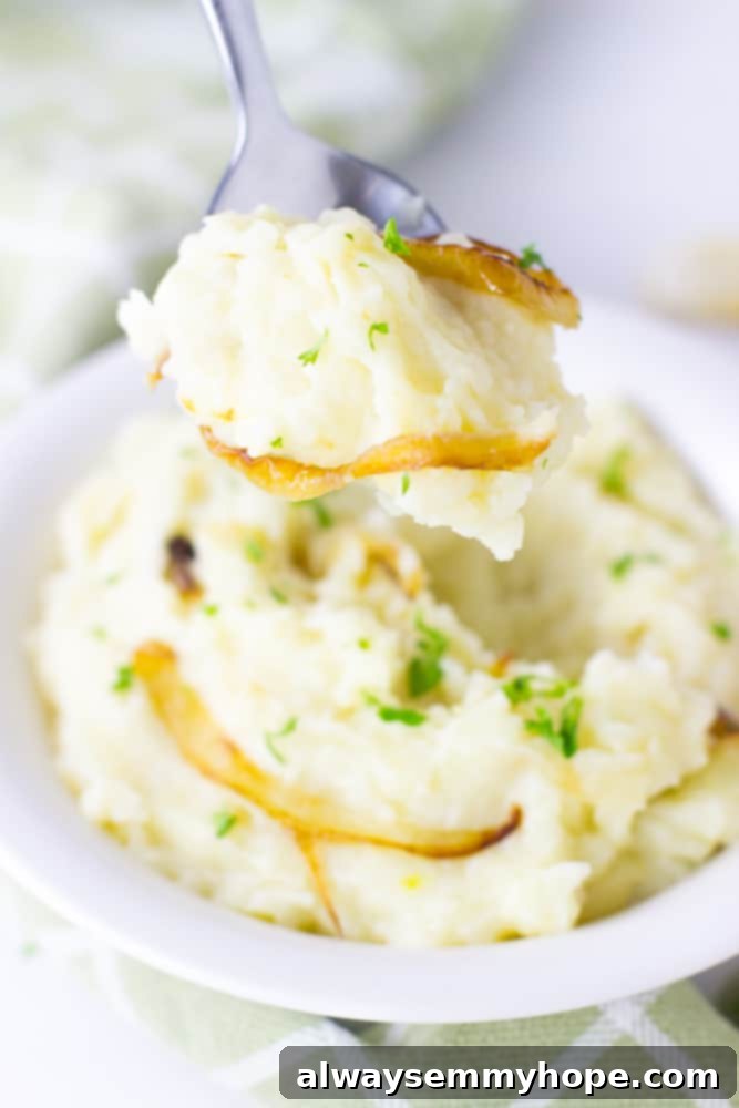 Close-up shot of fluffy vegan garlic mashed potatoes on a spoon, showcasing their creamy texture and inviting aroma.