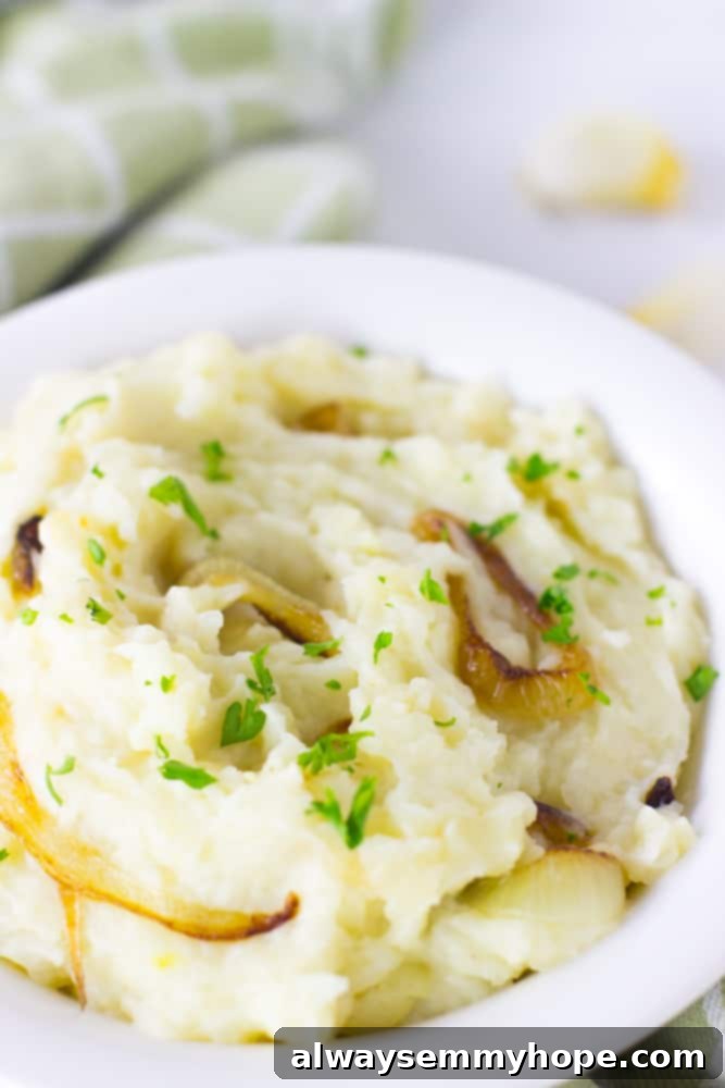 A close-up view of creamy vegan garlic mashed potatoes simmering gently in a white pot, ready to be seasoned and served.