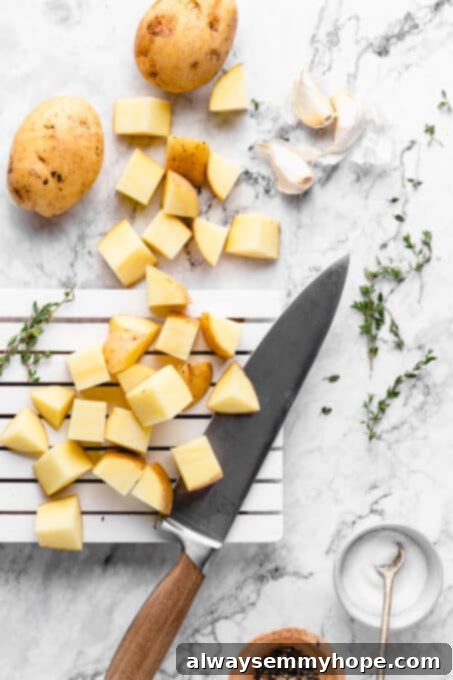Prep the potatoes. chopped potatoes and garlic on a marble board, ready for seasoning