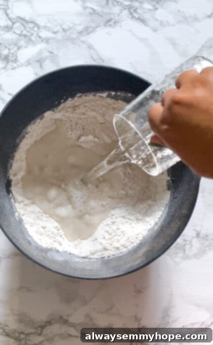 A bowl of white flour with a small well in the center, showing the initial dry ingredients for focaccia.