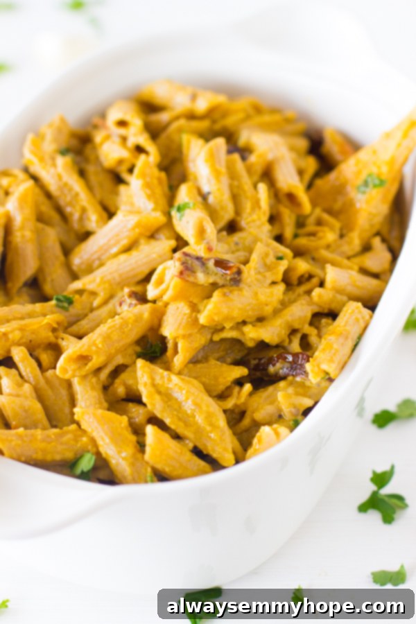 Creamy One-Pot Penne Alfredo 2 Alfredo penne pasta in a white bowl, garnished with fresh herbs.