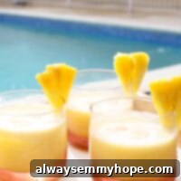 Close-up of a refreshing Pineapple Coconut Rum Cocktail with ice and a pineapple garnish.