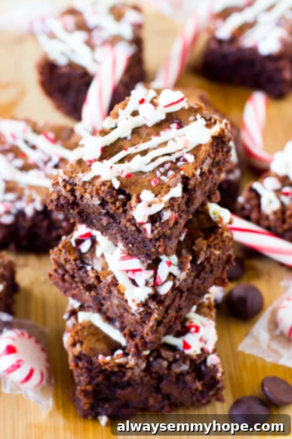 Stack of peppermint chocolate brownies on a wooden table top.