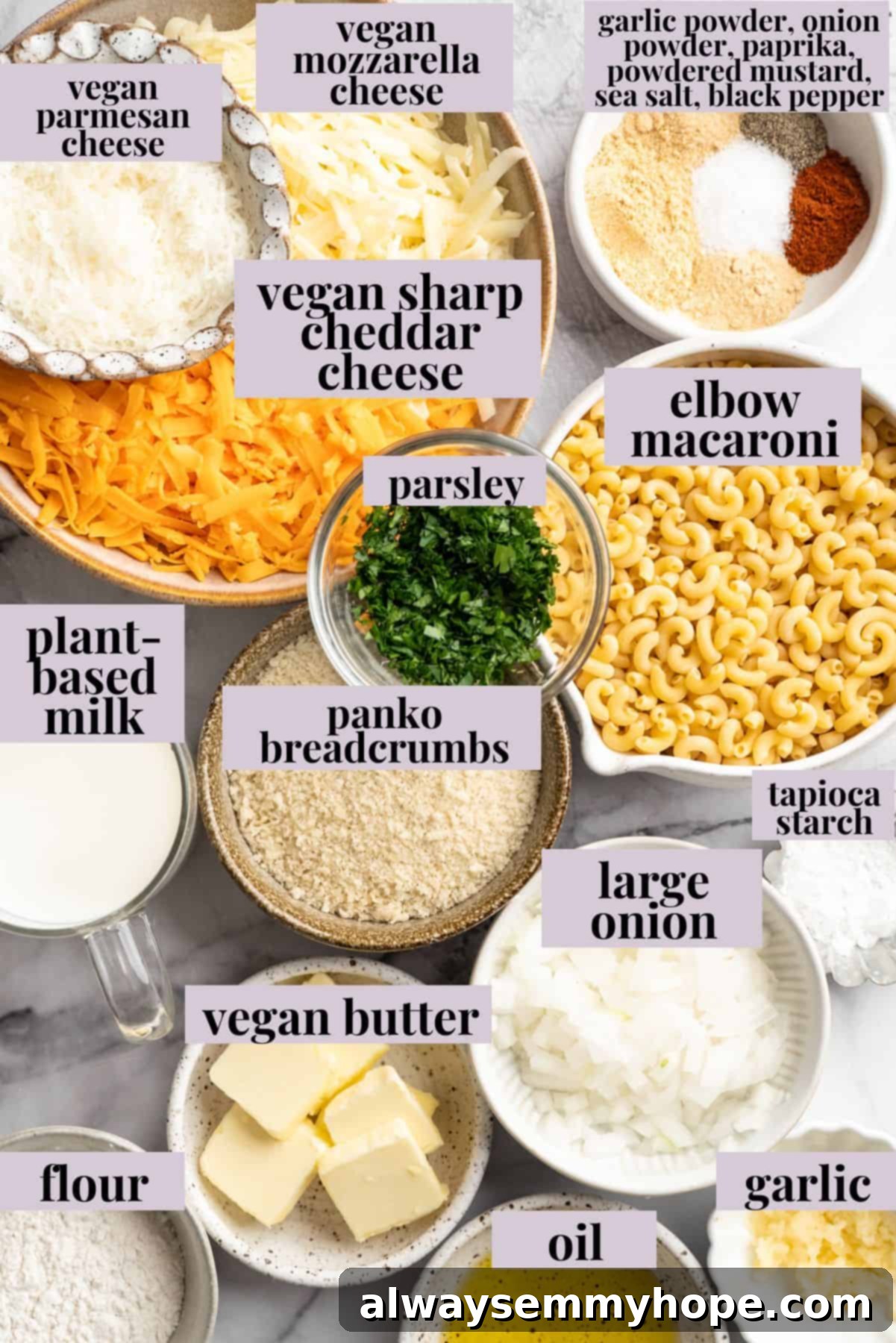 A vibrant selection of ingredients laid out for making 3-Cheese Vegan Mac and Cheese, including various vegan cheeses, elbow macaroni, plant milk, fresh garlic and onion, and spices.