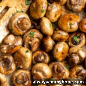 Garlic mushrooms in skillet with wooden spatula