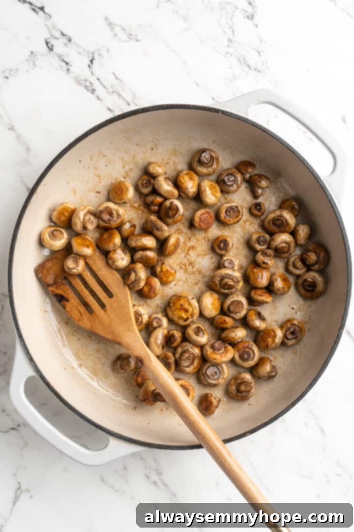 Overhead view of mushrooms browning in skillet
