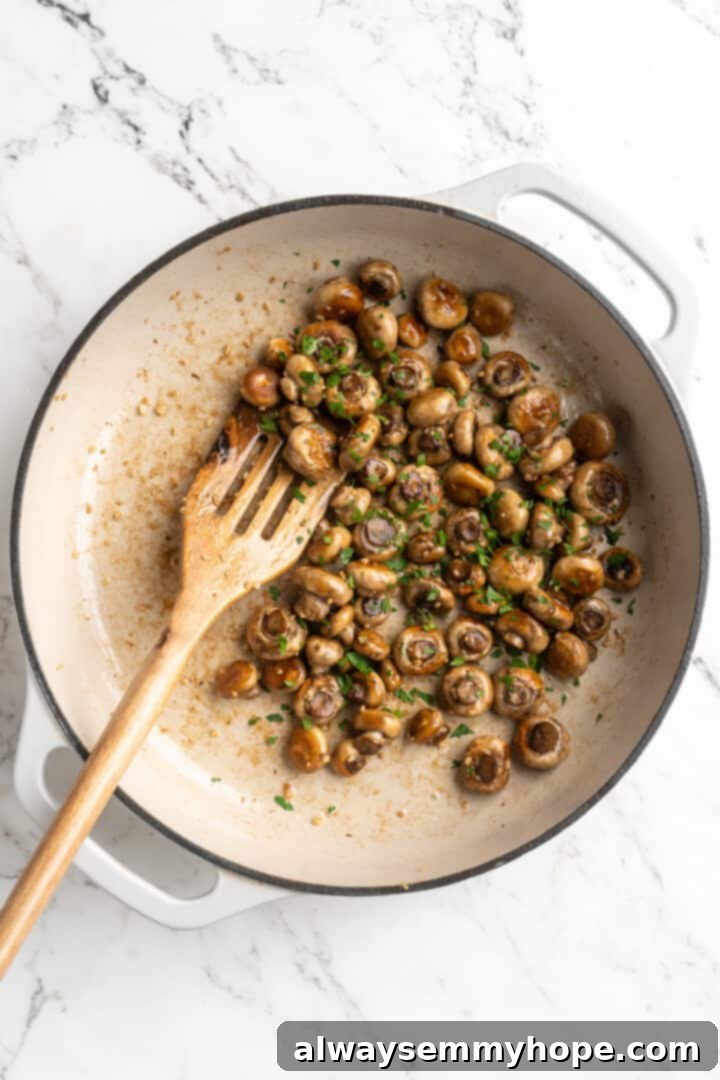 Overhead view of garlic mushrooms cooking in skillet