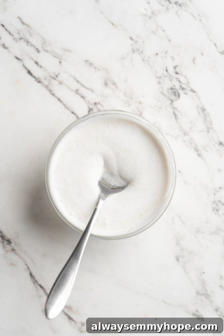 Overhead view of vegan yogurt mixture in a bowl with a spoon