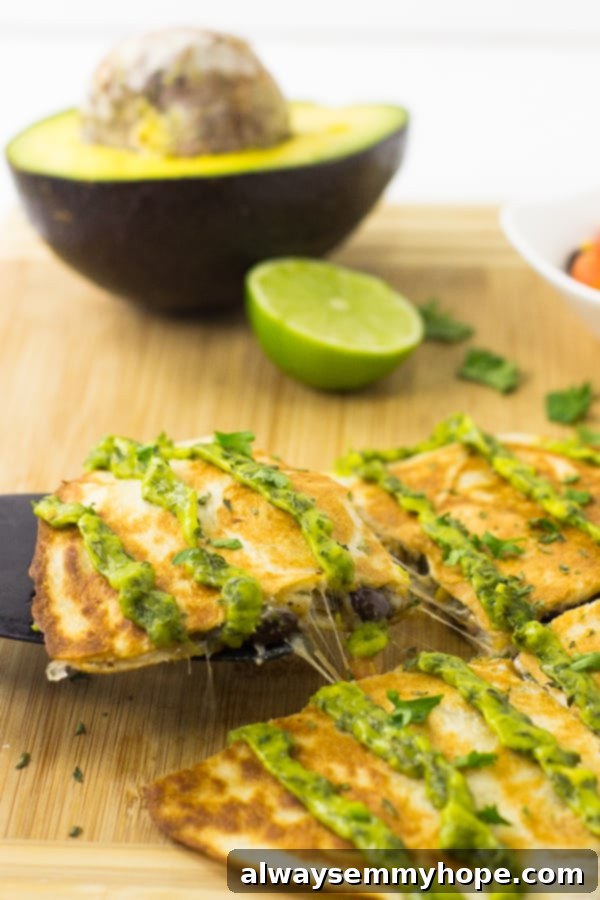 Crispy Mexican vegan quesadillas topped with avocado cilantro cream sauce, served on a rustic wood board. Perfect for a quick weeknight meal.