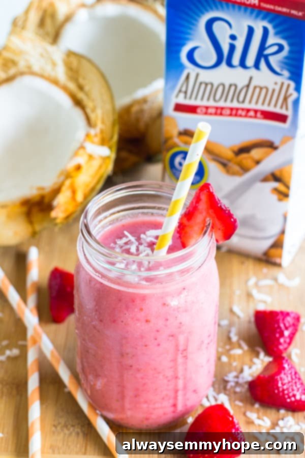Strawberry coconut smoothie in a mason jar with a straw.