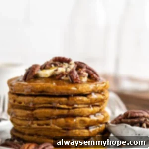 A stack of vegan gluten-free pumpkin pancakes on a plate, topped with nuts, next to a bowl of nuts.