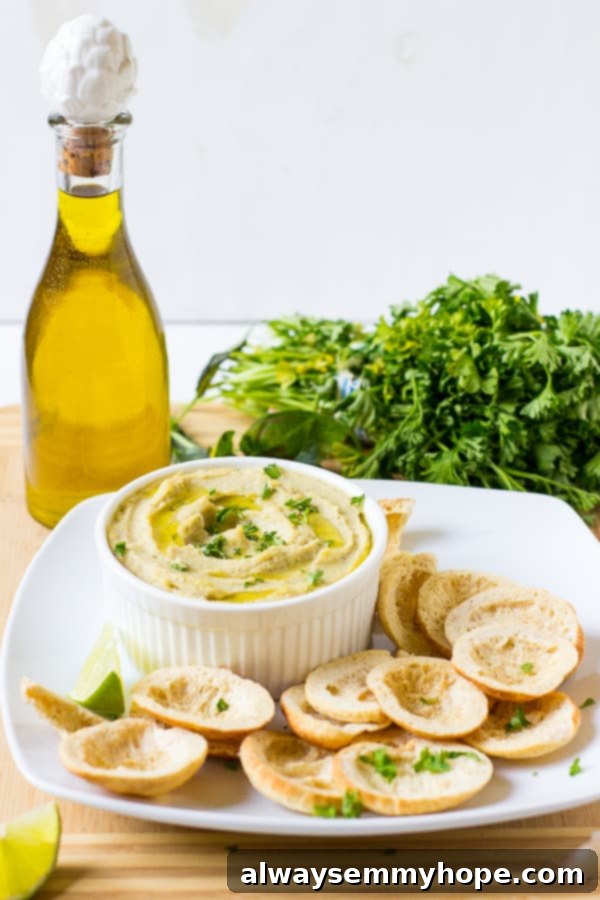 Side shot of herbed roasted garlic white bean dip in a ramekin, showing its creamy texture.