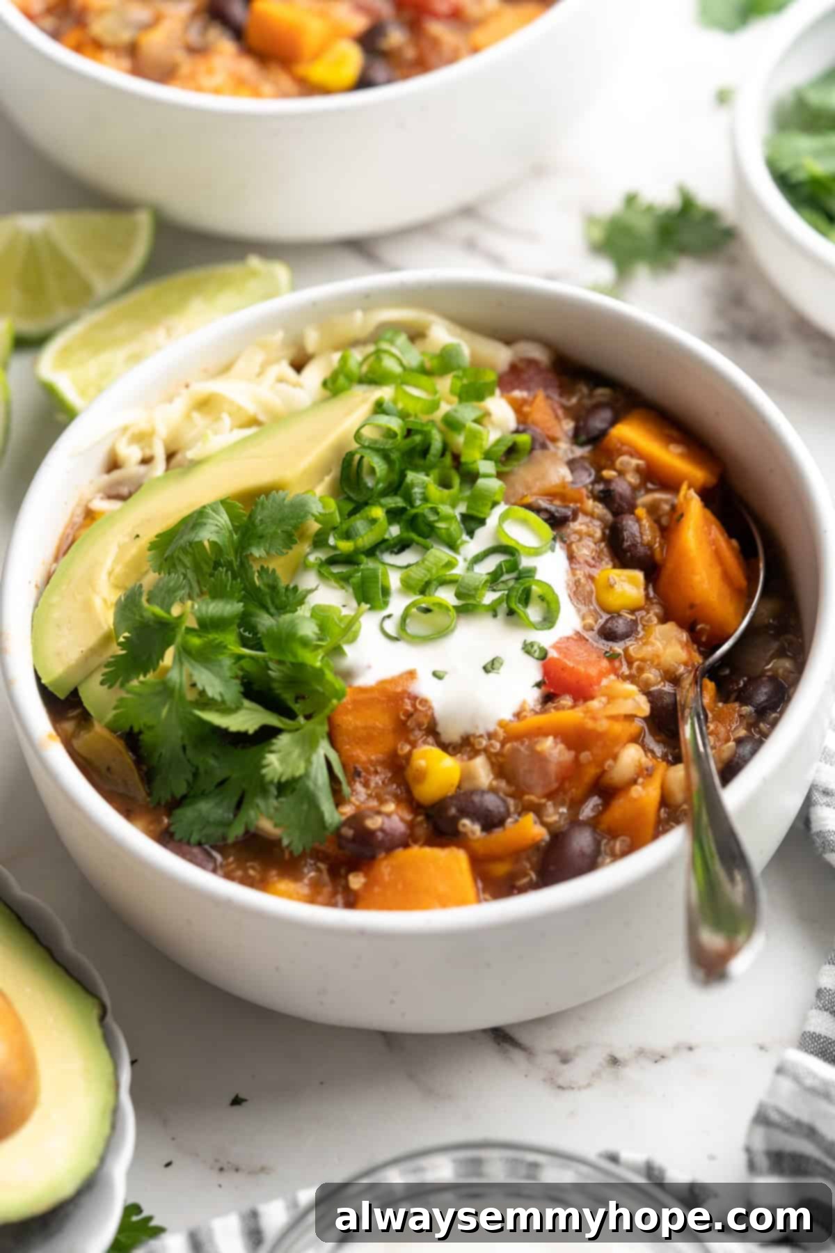 Bowl of sweet potato and black bean chili with garnishes