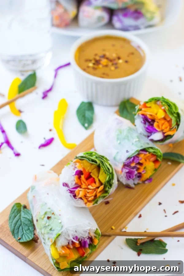 Four meticulously prepared fresh summer rolls resting on a wooden serving board, with a small bowl of creamy peanut ginger dipping sauce in the blurred background, highlighting their readiness to be enjoyed.