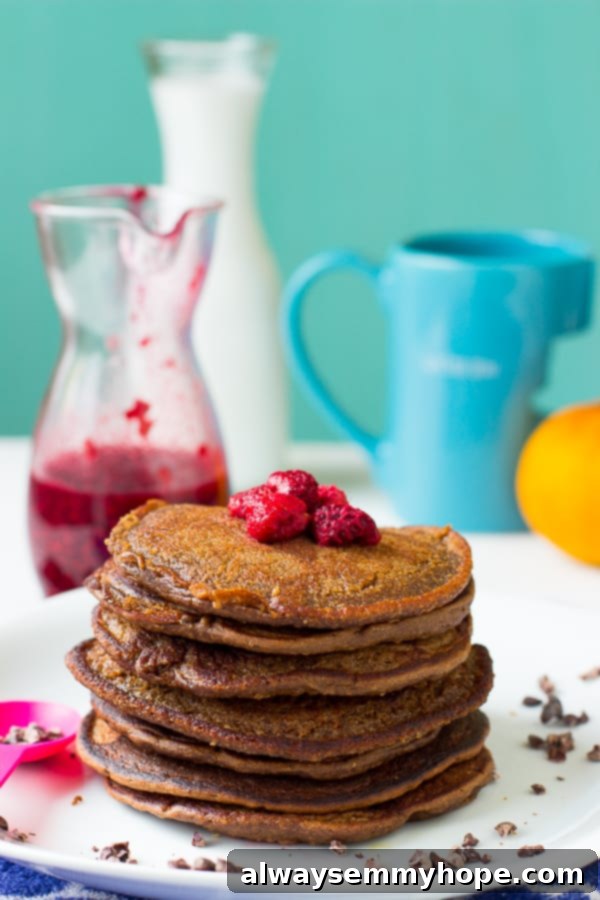 A beautifully presented pile of freshly made chocolate peanut butter pancakes on a white plate, ready for topping.